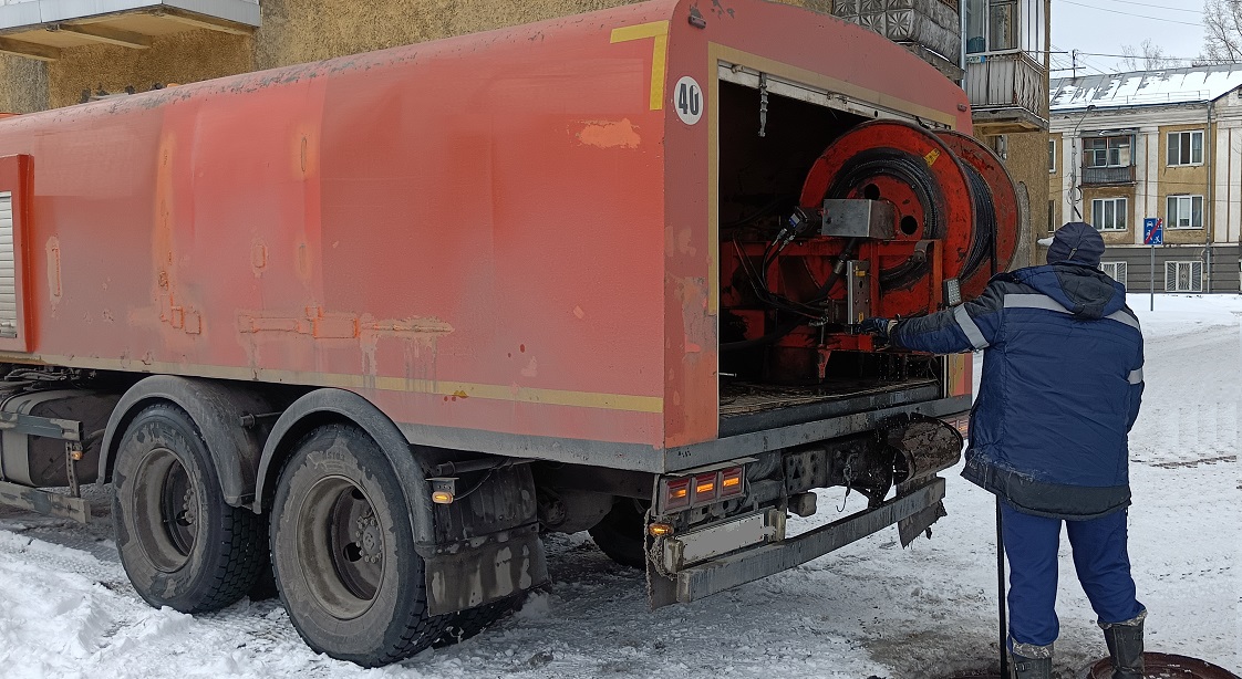 Каналопромывочная машина и работник прочищают засор в канализационной системе в Волгоградской области